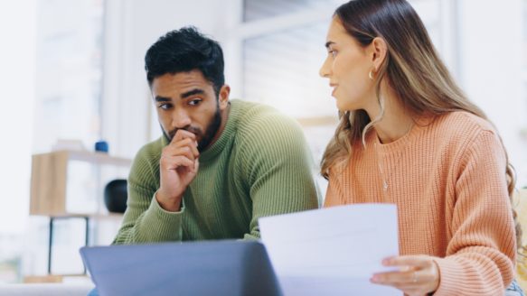Concerned couple reviewing finances on a laptop at home, reflecting on how the 2025 Alberta election results may affect their household budget.