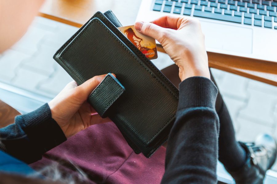 A woman reaches into her purse for her credit card. 