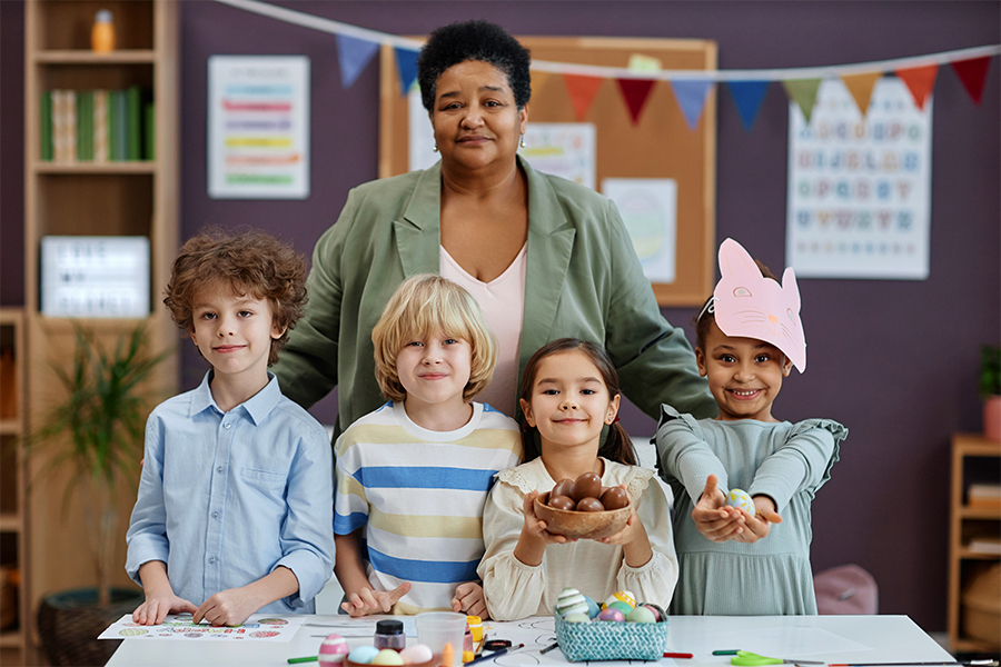 A teacher with young children in a classroom; save money on daycare costs with financial strategies from Money Mentors.