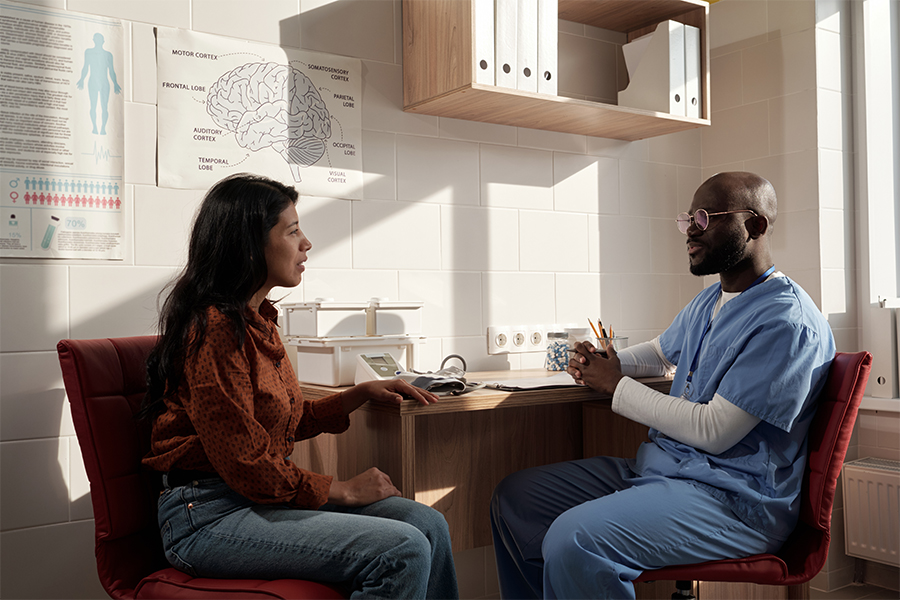 Doctor consulting with a patient in a medical office. Save money on healthcare expenses with financial advice from Money Mentors.