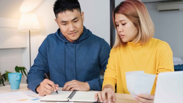 An Alberta couple comparing debt consolidation loan offers with the OPD program, highlighting the difference between private lenders and government-supported solutions.