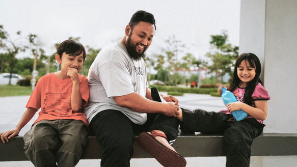 A smiling father smiling with his kids, representing hope and financial recovery after paying off $60K in payday loan debt through Alberta’s Orderly Payment of Debts (OPD) program.