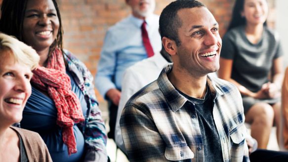 A smiling young man attends a free financial education class in Alberta
