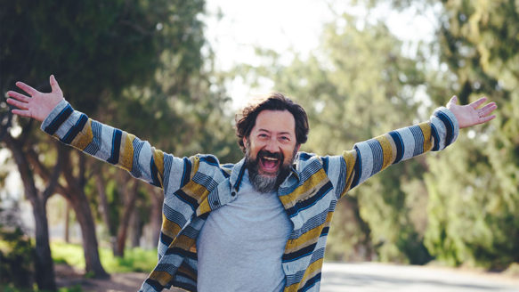 Happy man celebrating financial freedom after overcoming debt with Money Mentors' help