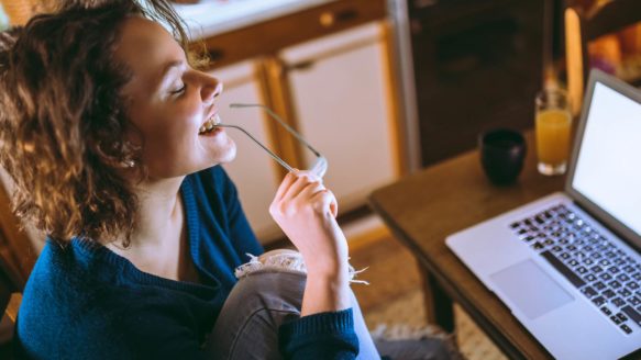 A young woman is researching credit counselling agencies on her laptop
