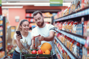 A couple compares prices in a grocery store