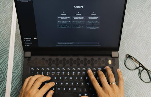 Hands typing on laptop with ChatGPT open