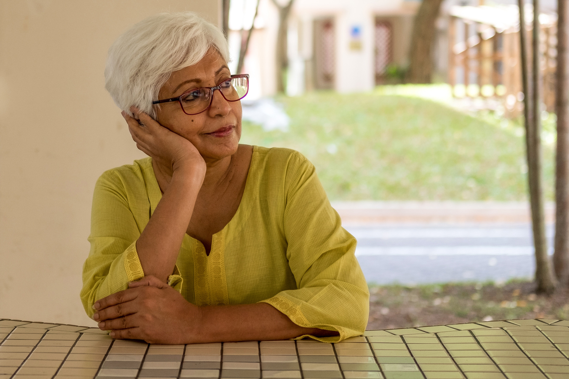 Elderly woman thoughtfully considering her retirement planning and debt-free future, highlighting the financial guidance and support from Money Mentors.